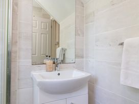 A bathroom sink with soap dispensers and a mirror above at Moorside in Horrabridge near Tavistock
