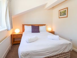 A bedroom with a double bed with white bedding and two rolled towels on the bed at Moorside Horrabridge near Tavistock