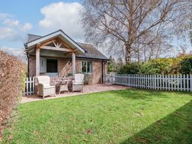 A house with a white fence and chairs in the front yard at The Lodge, Lower Trefedw in Pandy near Abergavenny