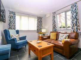 A living room with a sofa and armchair at The Lodge, Lower Trefedw, Pandy near Abergavenny