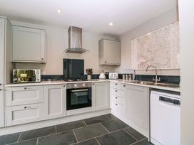 A kitchen with cabinets, stove, and sink at The Lodge, Lower Trefedw Pandy near Abergavenny