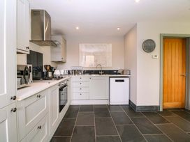 A kitchen with appliances and cabinets at The Lodge, Lower Trefedw in Pandy near Abergavenny