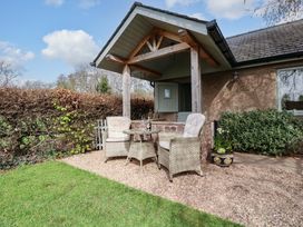 A patio with chairs and a table at The Lodge, Lower Trefedw near Abergavenny