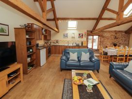 A living room with a sofa and dining area at Hayloft Cottage in Bolton Low Houses