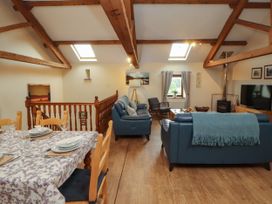 A living room with a sofa and dining area at Hayloft Cottage Bolton Low Houses