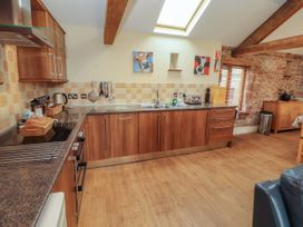 A kitchen with wooden cabinets and a sink at Hayloft Cottage Bolton Low Houses