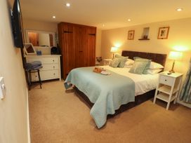 A bedroom with a double bed and wooden wardrobe at Hayloft Cottage Bolton Low Houses