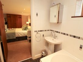 A bathroom with sink and mirror leading to a bedroom at Hayloft Cottage Bolton Low Houses