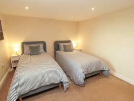 A bedroom with two beds and bedside tables at Hayloft Cottage Bolton Low Houses