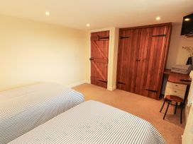 A bedroom with two beds and wooden furniture at Hayloft Cottage Bolton Low Houses