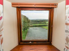 A view from a window showing grass and gravel outside at Horseshoe Cottage in Bolton Low Houses