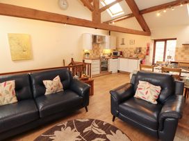 A living room with a sofa and kitchen area at Horseshoe Cottage in Bolton Low Houses