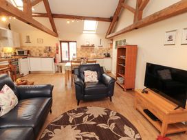 A living room with a sofa and dining area at Horseshoe Cottage in Bolton Low Houses