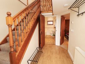 A hallway with staircase and doors to a bathroom and bedroom at Horseshoe Cottage Bolton Low Houses