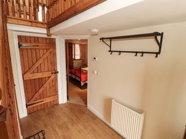 A hallway with a wooden door, coat rack, and radiator at Horseshoe Cottage in Bolton Low Houses
