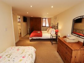 A bedroom with double and single beds at Horseshoe Cottage in Bolton Low Houses