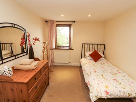 A bedroom with a bed and dresser at Horseshoe Cottage in Bolton Low Houses