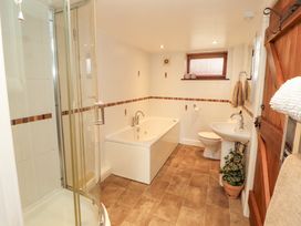 A bathroom with a shower, bathtub, and sink at Horseshoe Cottage in Bolton Low Houses