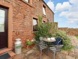An outdoor seating area with a table and chairs at Horseshoe Cottage Bolton Low Houses