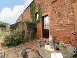 An outdoor seating area with a table and chairs at Horseshoe Cottage in Bolton Low Houses