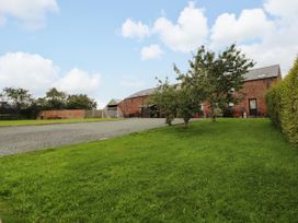 An outdoor area with a building and trees at Horseshoe Cottage Bolton Low Houses