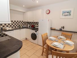 A kitchen with appliances and dining table at Garth Cottage in Haverfordwest