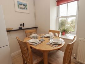 A dining room with a table set for four at Garth Cottage in Haverfordwest
