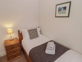 A bedroom with a single bed and nightstand at Garth Cottage Haverfordwest