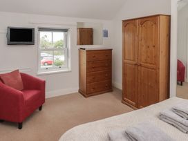 A bedroom with furniture including a television and a wardrobe at Garth Cottage in Haverfordwest