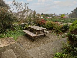 A garden with a picnic table in gravel at Garth Cottage Haverfordwest