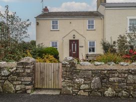 A cottage with a stone wall and wooden gate at Garth Cottage Haverfordwest