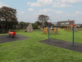 A playground with swings and climbing equipment at Garth Cottage in Haverfordwest
