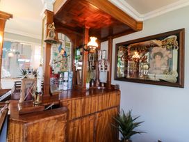A bar counter with bottles and a decorative mirror at Boathouse in Deganwy near Llandudno