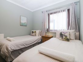 A bedroom with two single beds and a bedside table at Boathouse in Deganwy near Llandudno