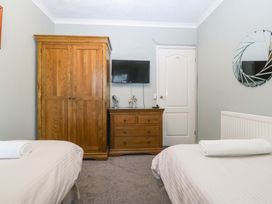 A bedroom with twin beds and a wardrobe at Boathouse in Deganwy near Llandudno