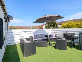 A patio area with furniture and a grill at the Boathouse in Deganwy near Llandudno