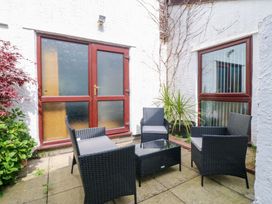 A patio with outdoor seating and a glass table at Boathouse in Deganwy near Llandudno