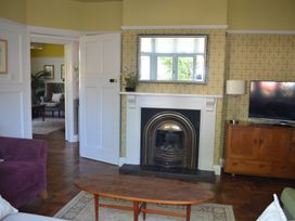 A living room with a fireplace mirror television wooden cabinet and coffee table at Lily House in Minehead