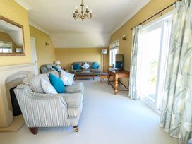 A living room with a sofa and television at Bryn y Don in Benllech