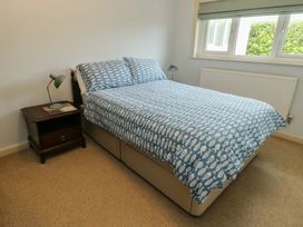 A bedroom with a bed and bedside table at Bryn y Don in Benllech