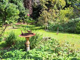 A garden with a birdbath and croquet equipment on grass at West Ridge in Boscombe