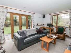 A living room with a sofa, coffee table, and desk at Geryllan Rhandirmwyn near Llandovery