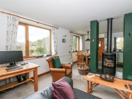A living room with a computer and a fireplace at Geryllan Rhandirmwyn near Llandovery
