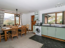 A kitchen with a dining table and washing machine at Geryllan Rhandirmwyn near Llandovery