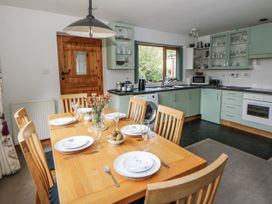A kitchen with a dining table and chairs at Geryllan in Rhandirmwyn near Llandovery