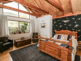 A bedroom with a wooden bed and a window at Geryllan Rhandirmwyn near Llandovery