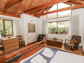 A bedroom with a bed and wooden furniture at Geryllan in Rhandirmwyn near Llandovery