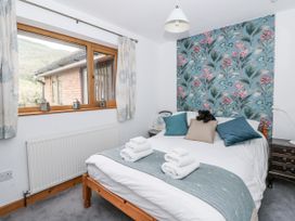 A bedroom with a bed and window at Geryllan in Rhandirmwyn near Llandovery
