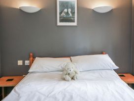 A bedroom with a bed and a teddy bear at Geryllan Rhandirmwyn near Llandovery