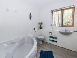 A bathroom with a bathtub, toilet, and sink at Geryllan in Rhandirmwyn near Llandovery